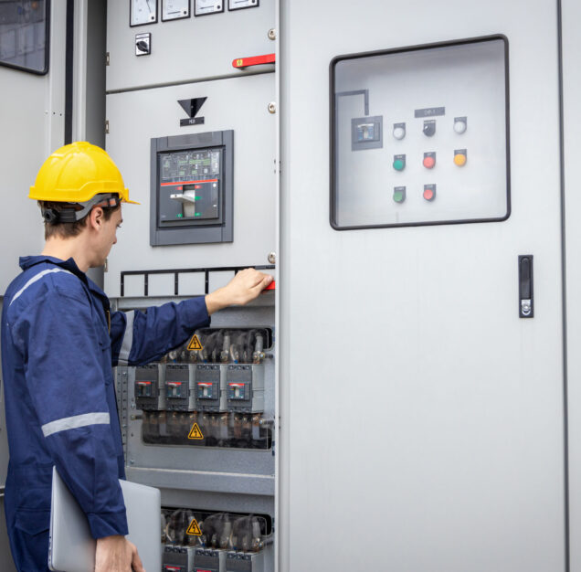 Electrical engineer working in control room. Electrical engineer man checking Power Distribution Cabinet in the control room
